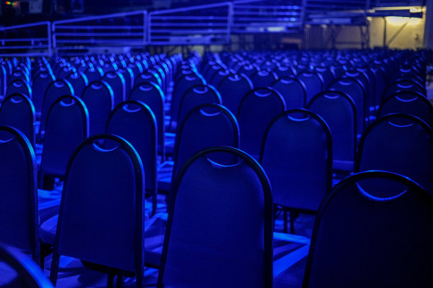 礼堂或剧院的空座位，室内有蓝光灯图片下载