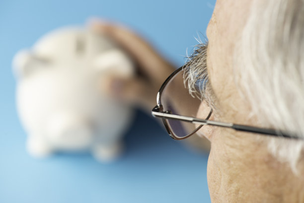 高级男子拿着储蓄罐。图片下载