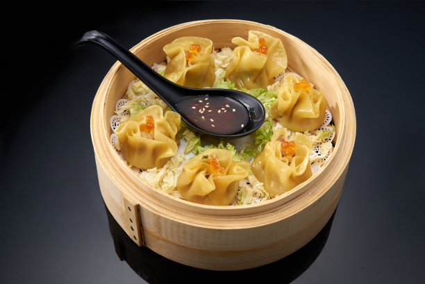 亚洲美食:海鲜和鱼子酱包在竹制双层锅里，深色背景上是酱油图片下载