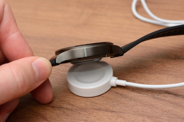 智能手表手持在手机上无线充电，近景拍摄图片下载