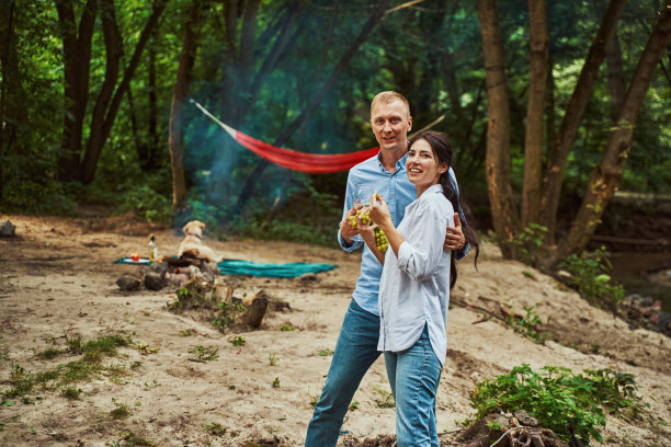 在森林野餐时微笑的年轻情侣图片下载