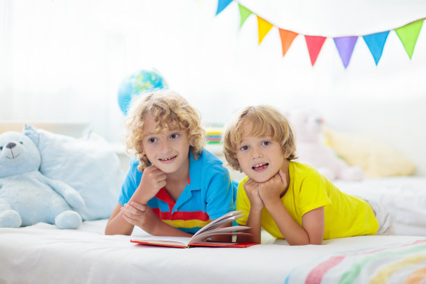 孩子在床上看书。孩子们读书。孩子在家。图片下载