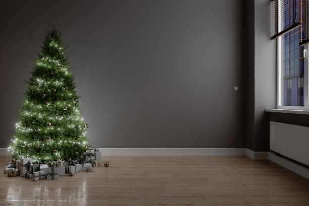 在晚上的空房间里有装饰，灯和礼品盒的圣诞树。图片下载