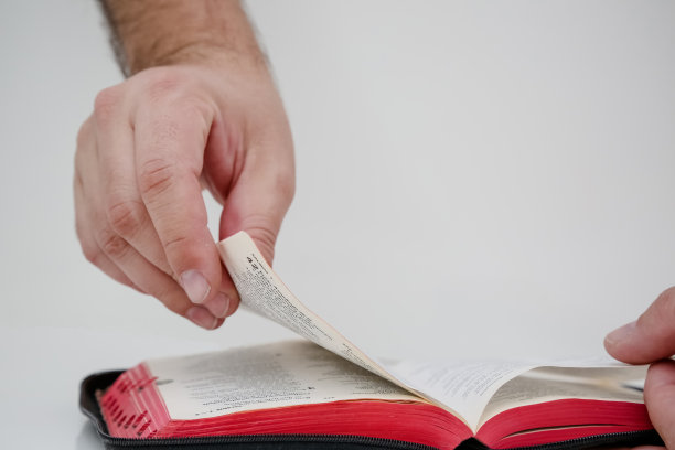圣经在手里打开，让人翻阅。图片下载