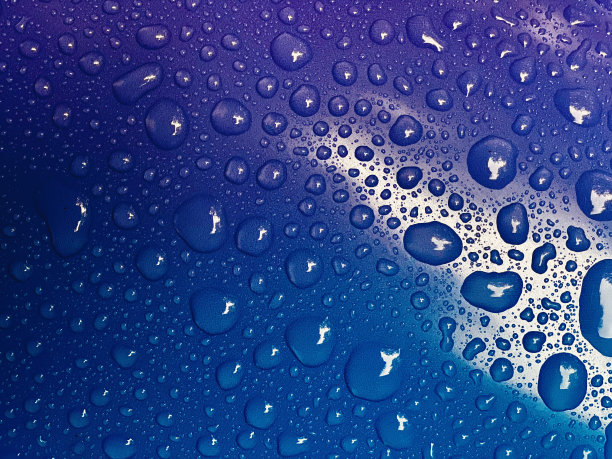 紫色和蓝色背景上的雨滴的特写。图片下载