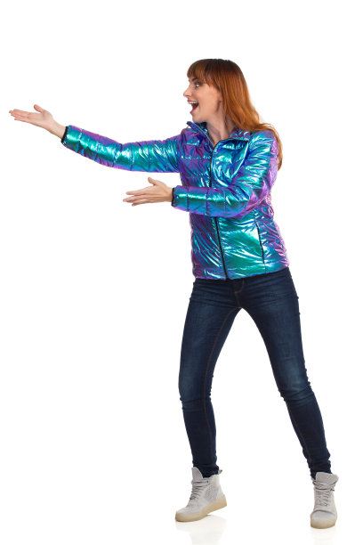 兴奋的年轻女子穿着冬衣，展示着什么，并大喊。图片下载