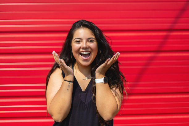 拉美裔美国原住民一代Z女性站在红色车库门前的城市照片系列图片下载