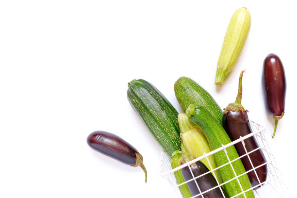 秋天作文用蔬菜。整个成熟的西葫芦和茄子放在白色背景的金属柳条篮子里。收割。食品配料。副本的空间。图片下载
