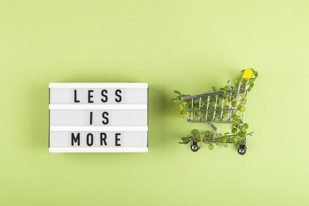 购物车与绿色背景的植物缠绕在衣架之间。可持续的生态的生活方式。图片下载