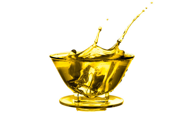 将冰块滴入白色背景下金黄色液体的玻璃杯中，产生飞溅效果。图片下载