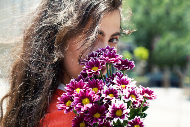 一个女人躲在花束后面的画像图片下载