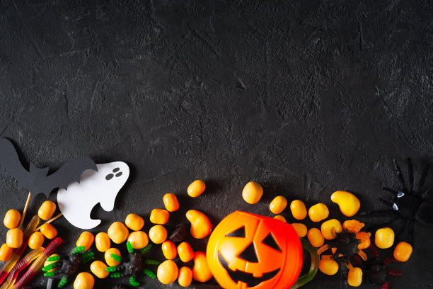 万圣节派对概念与糖果和有趣的南瓜在黑色的背景图片下载