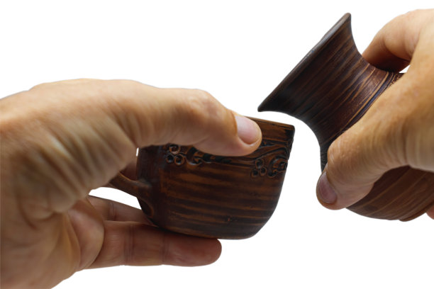 棕色的陶瓷杯和水壶在近距离。孤立的图片下载