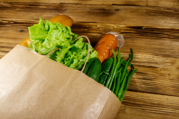 木桌上有纸袋和不同的食物。超市购物的概念图片下载