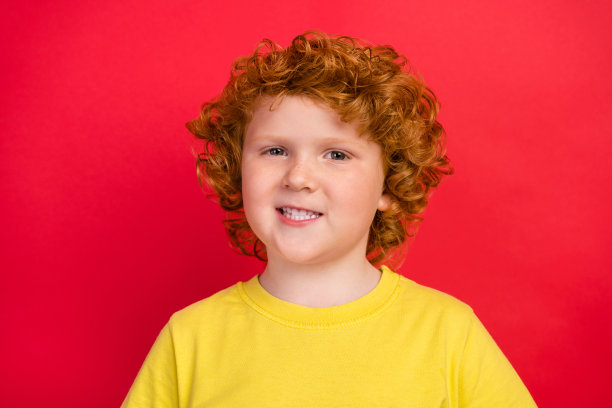 照片foxy正面开朗的好高兴的男孩灿烂的微笑穿着黄色t恤孤立的红色背景图片下载