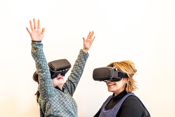 母女俩戴着虚拟现实眼镜玩游戏，母女俩戴着虚拟现实耳机玩游戏，隔离在白色上，家庭和科技的概念图片下载
