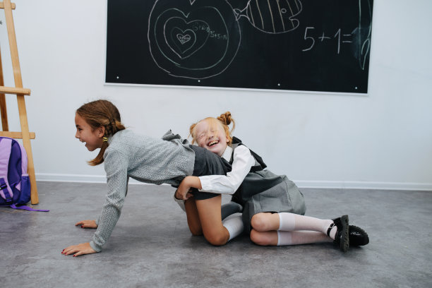 愚蠢的女生玩。一个趴在地上，另一个趴在她身上图片下载