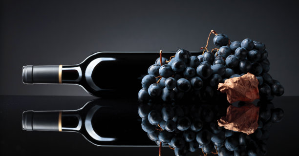 一瓶红酒和一串葡萄。图片下载
