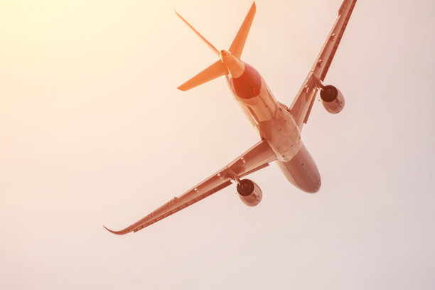 在太阳背光照射下的傍晚云层背景下飞行的客机。旅游、度假、旅行的概念。图片下载