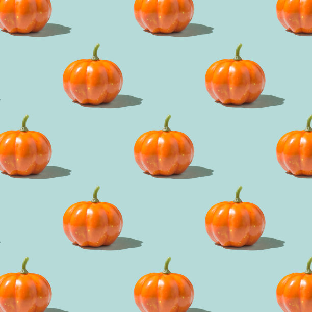 万圣节快乐的概念。橙色南瓜的照片与阴影图案孤立在浅蓝色背景上图片下载