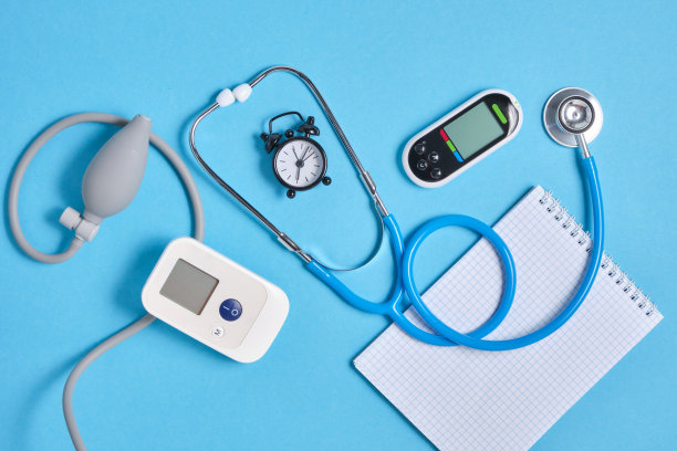 数字血压计，血糖仪，听诊器，记事本和闹钟在蓝色背景顶部视图图片下载
