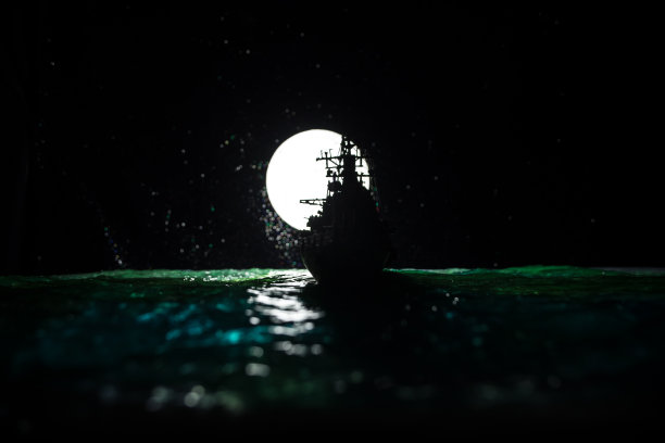 在雾蒙蒙的背景中，一群人站在模糊的军用战舰前的剪影。有选择性的重点。图片下载