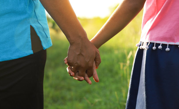 母女俩手牵着手在公园里散步。图片下载