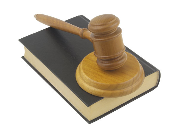 法官在法律书上敲打小槌，孤立在白色背景上图片下载
