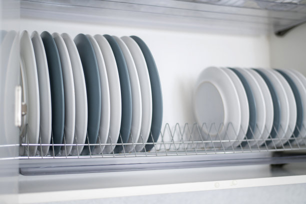 盘子又平又深地堆放在厨房的烘干机上图片下载