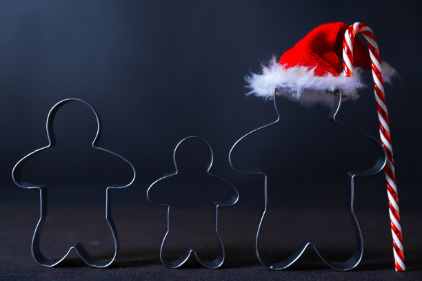 姜饼人形状的圣诞饼干切割机。快乐家庭假日概念。图片下载