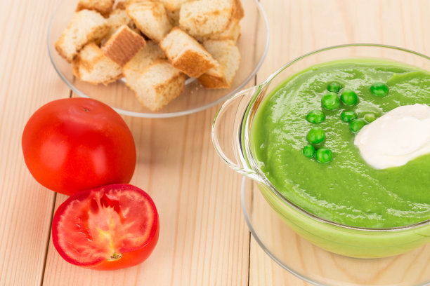 木制的表面上有绿色奶油汤。图片下载