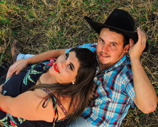 男人戴着牛仔帽，抱着怀孕的妻子——乡村生活理念图片下载