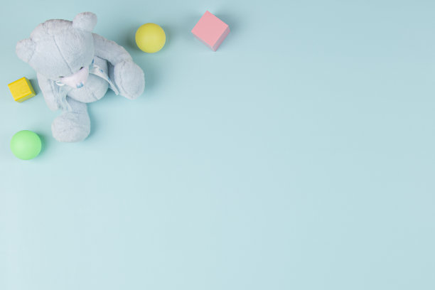 婴儿儿童玩具背景与泰迪熊，木块和彩色球在浅蓝色的背景。俯视图，平躺图片下载