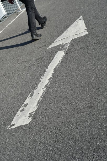 一个巨大的白色箭头方向标志，有一个人走在旁边图片下载