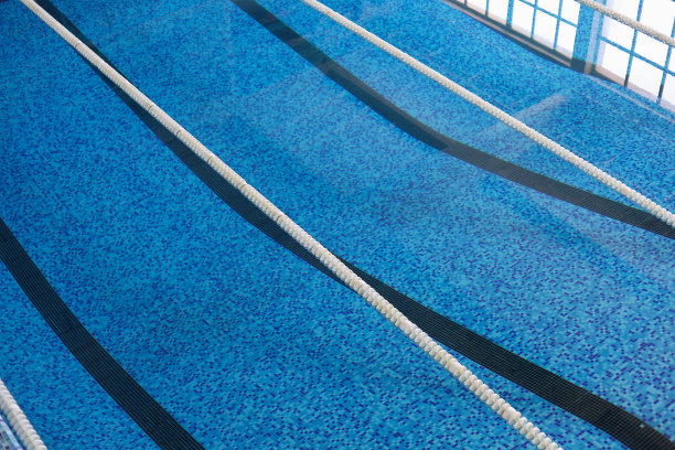 光滑的水在一个经典的运动游泳池与泳道。抽象的背景图片下载