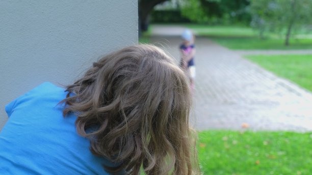 两个年轻的白人女孩在公共城市公园玩捉迷藏图片下载