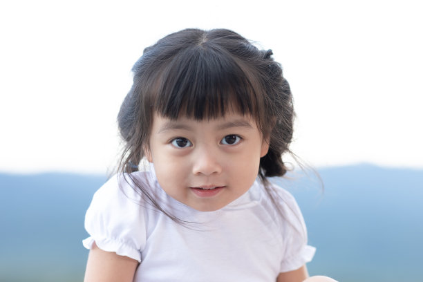 可爱的小女孩看着相机微笑，幸福。可爱的亚洲儿童微笑和放松与户外活动。孩子在户外玩的概念图片下载