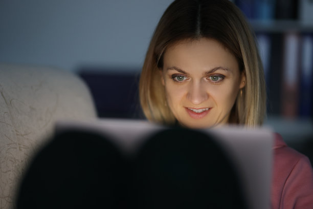 黑暗中的女人肖像看着平板电脑屏幕图片下载