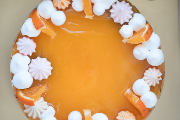 用许多糖果装饰的橙色蛋糕的特写镜头。俯视图图片下载