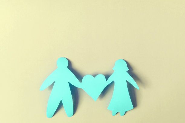 鲜艳的红色人像和彩色背景上的一颗心。幸福关系的概念。纸板人偶图片下载