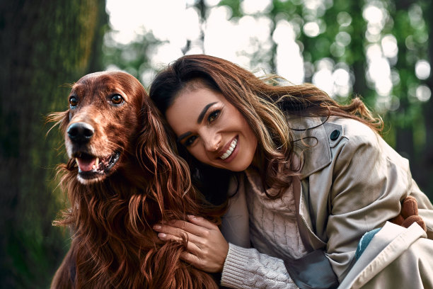 公园里一位迷人的女人和一只美丽的棕色纯种狗的特写照片。爱，关心一只宠物。图片下载