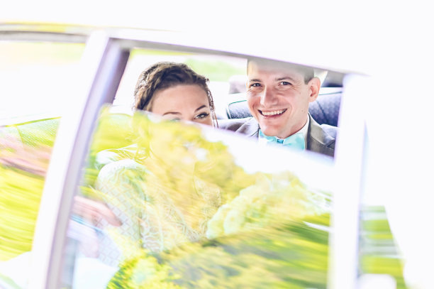 婚礼当天，新娘和新郎在一辆豪华轿车或汽车的后座上放松图片下载