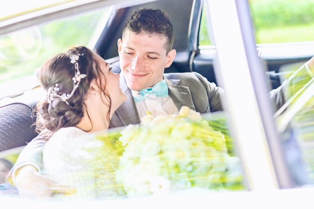 婚礼当天，新娘和新郎在一辆豪华轿车或汽车的后座上放松图片下载