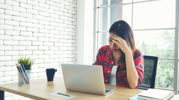 经济衰退压力女性使用笔记本电脑在家办公头痛，疲惫的失败业务挫折。压力大的亚洲女性焦虑过度工作，痛苦与生活危机累压力大的失业图片下载