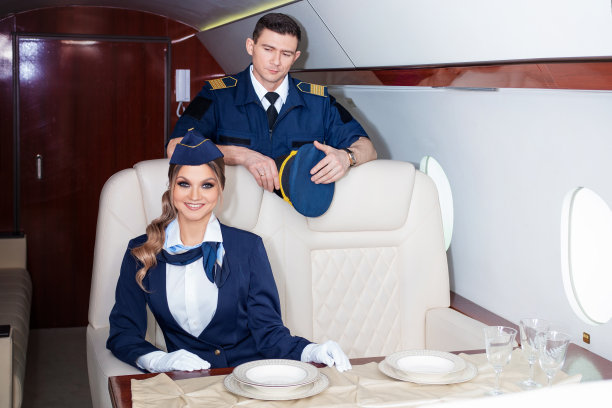 身穿制服的空姐在飞机上问候一位美丽的年轻女子，图片下载