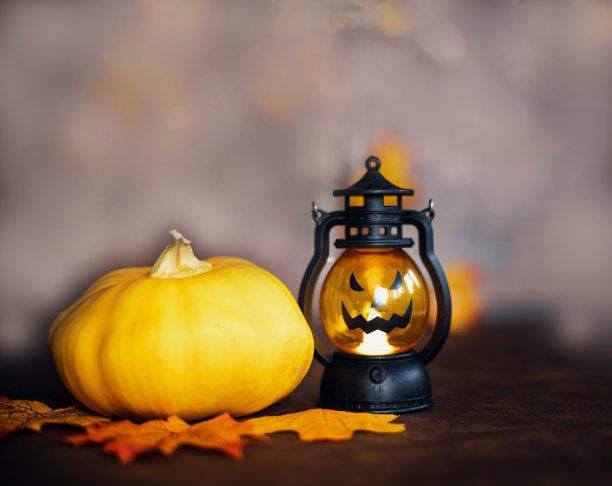 万圣节南瓜在秋天的叶子和杰克灯笼在棕色木制背景纹理，万圣节，秋天和十月的概念图片下载