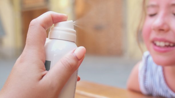 快乐可爱的白人女孩得到她的脸清凉喷雾在酷热的夏天图片下载