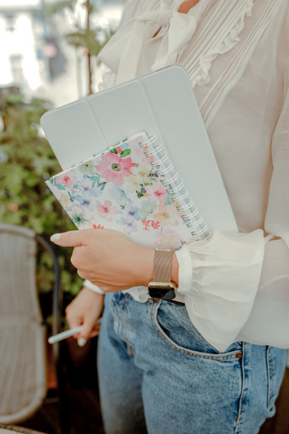 穿着白衬衫，拿着表，手里拿着笔记和笔的女人图片下载