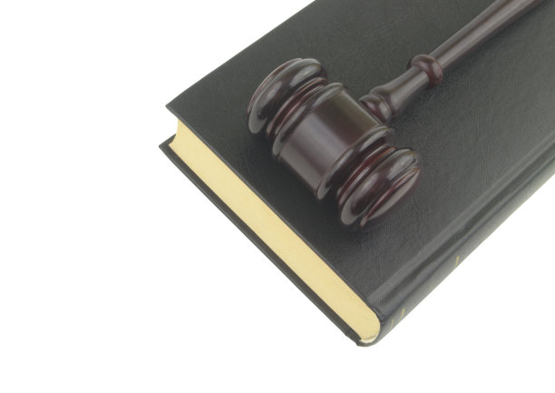法官在法律书上敲打小槌，孤立在白色背景上图片下载