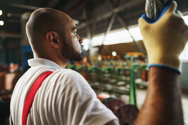 身穿制服的工程师使用吊车控制器吊在工厂的天花板上图片下载